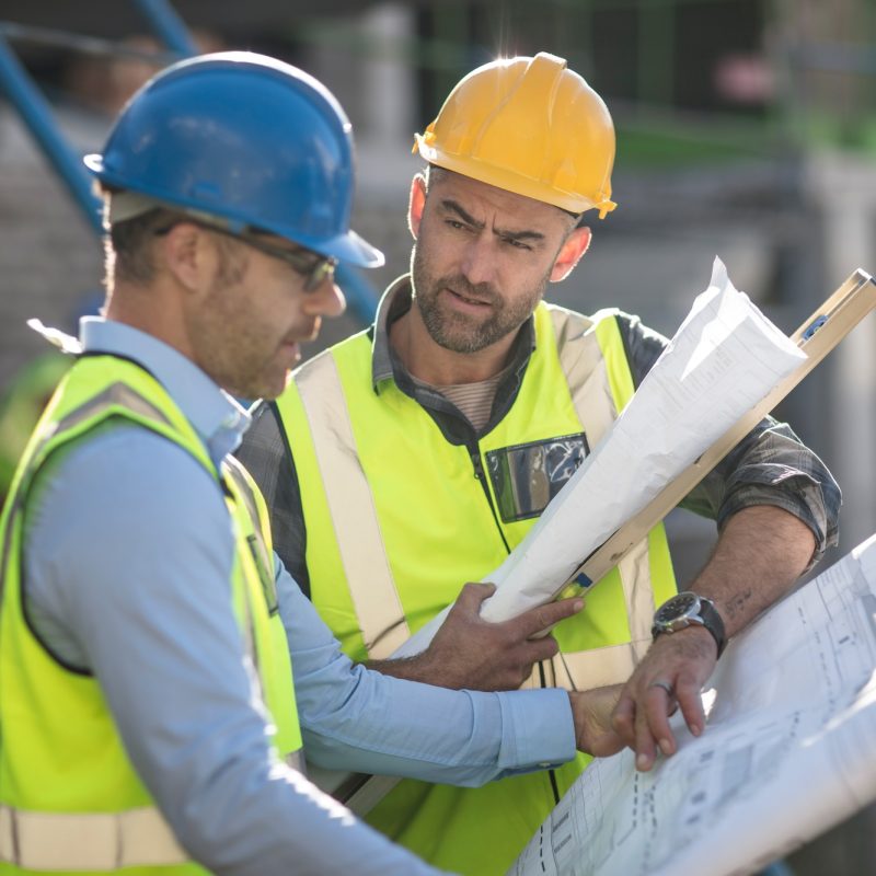 Project manager and construction worker looking at plans Project manager and construction worker looking at plans